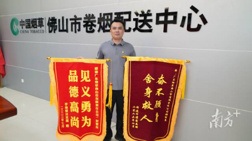 彭智良手持被救者送来的锦旗。
