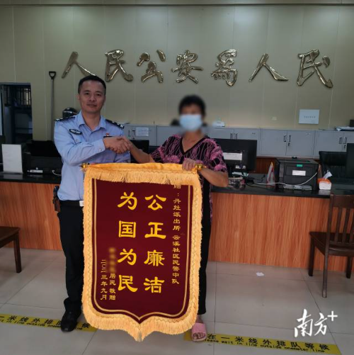 林先生夫妇向丹灶民警赠送锦旗。通讯员供图