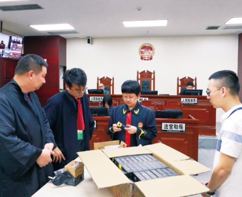 广州知识产权法院张姝法官（右二）团队组织双方当事人对一起侵害外观设计专利权纠纷案件的涉案物证进行比对。