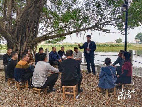 隆都镇基层干部在榕树下为村民宣讲民法典。
