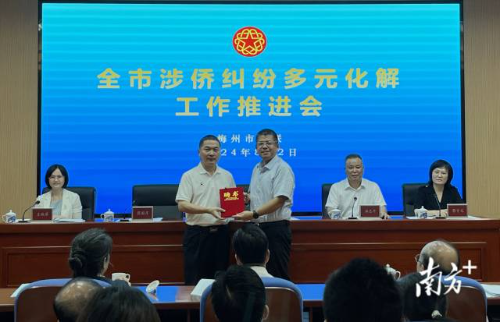 崔毅（右）为市侨联法顾委主任蔡国芹颁发聘书
