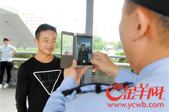 阿sir拿手机对过往路人进行刷脸盘查