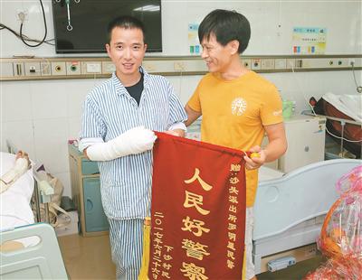 下沙居民看望罗明星（左），并送上锦旗。